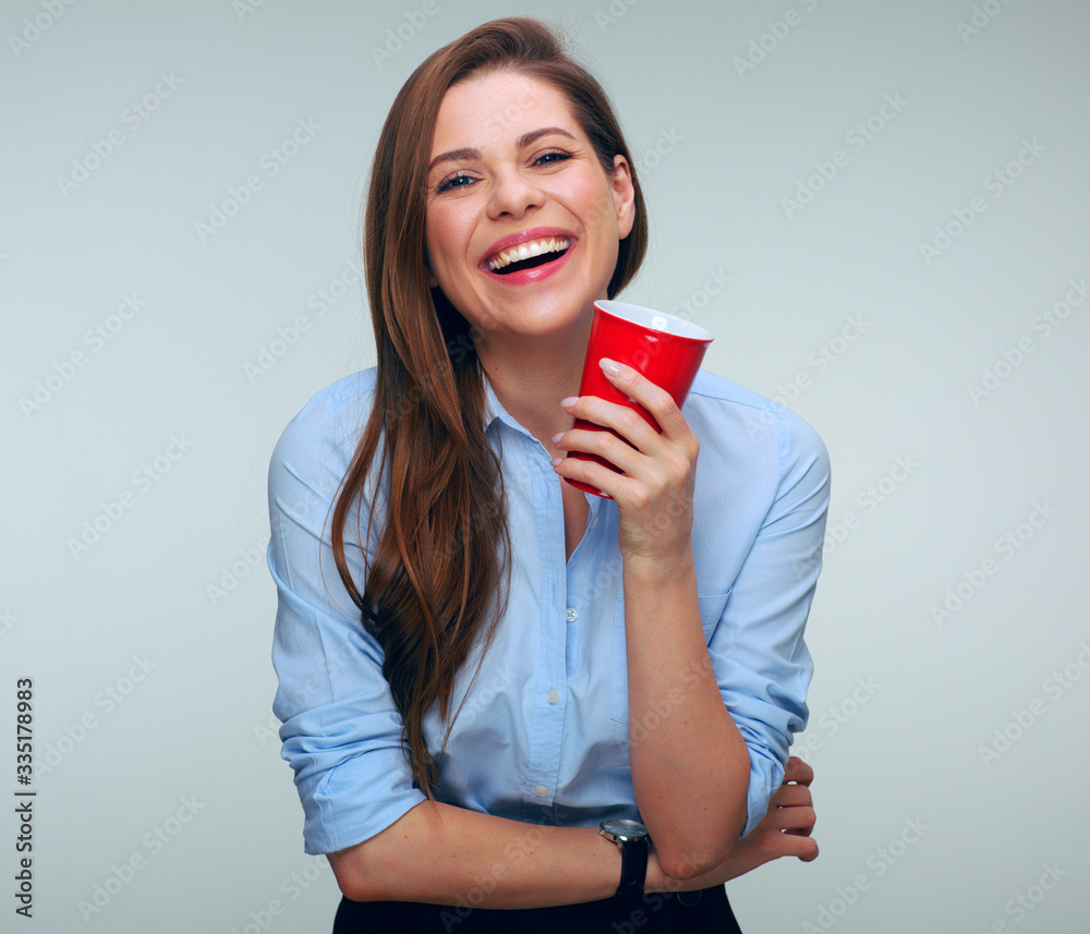 Happy woman in blue shirt drinking coffee with big red cup.