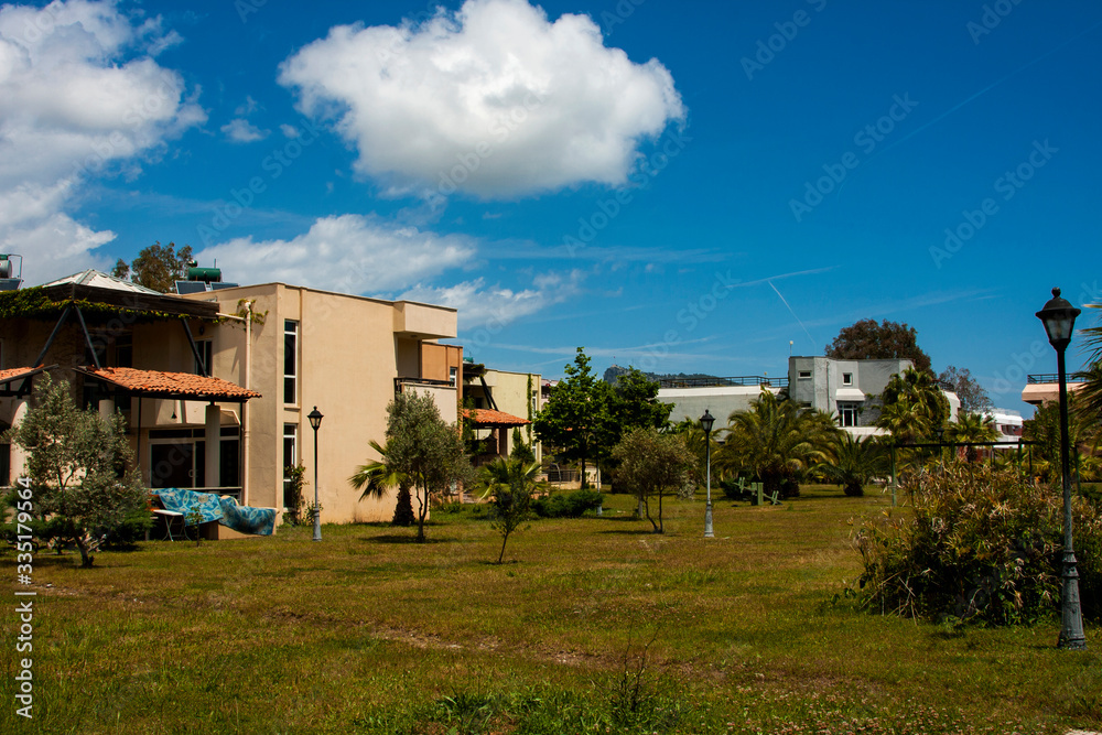 Fototapeta premium Cottages, grass, green trees and blue sky