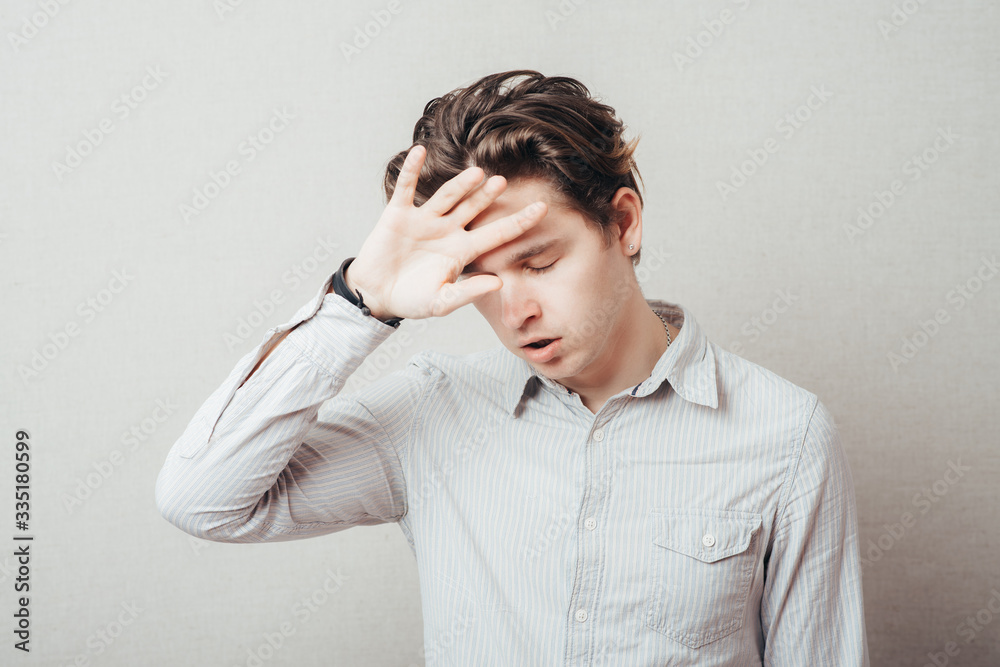 Handsome man with headache and the hand on forehead isolated on a white background Handsome man with headache and the hand on forehead isolated on a white background