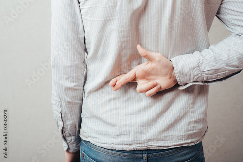 young man crossed his fingers behind his back
