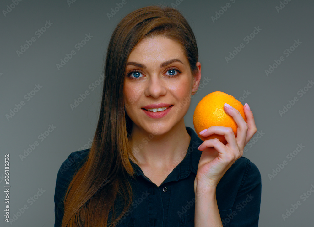 Smiling woman holding whole orange.