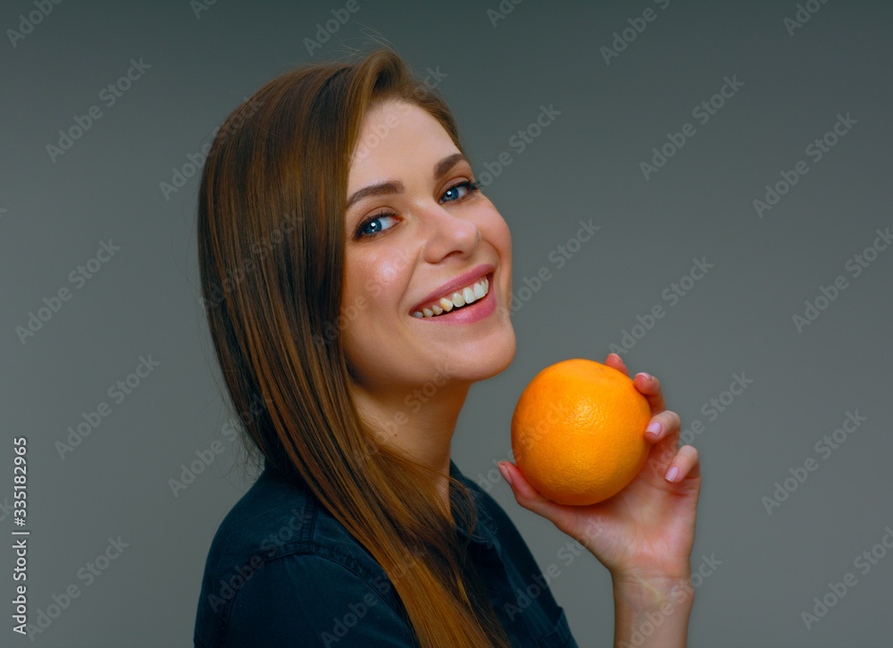 Smiling woman holding whole orange. Smiling woman holding whole orange.