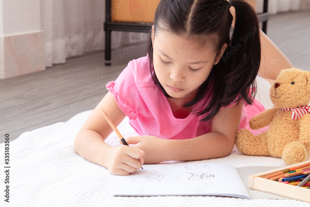 Asian home school elementary adorable kids lie down on floor, drawing homework with color pencils, happy cheerful girl spent time concentrate drawing quarantine period before back to school Asian home school elementary adorable kids lie down on floor, drawing homework with color pencils, happy cheerful girl spent time concentrate drawing quarantine period before back to school