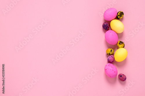 Happy easter concept. Colored eggs on a pink background. Copy space flat layout. Banner with place for advertising.