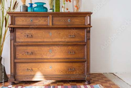 old antique old mahogany chest of drawers in a room with additional decor. interesting design photo