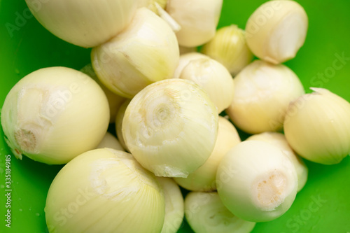 Fresh peeled onions in a green cup