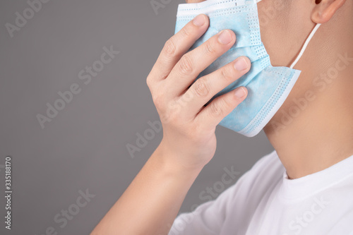 People coughing  wearing protective masks on a gray background in the studio