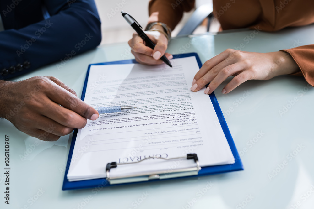 Two Businesspeople Analyzing Document Two Businesspeople Analyzing Document