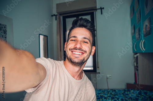 Handsome caucasian man taking a self portrait indoor at home