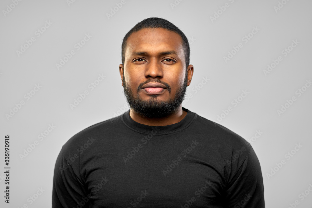 people concept - portrait of young african american man in black t-shirt over grey background