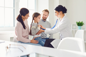 Happy family on a visit to the doctor in the office of a doctor.