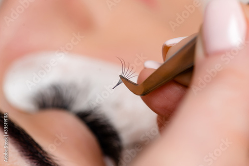 Eyelash Extension Procedure. Woman Eye with Long Eyelashes. Lashes, close up, macro, selective focus.