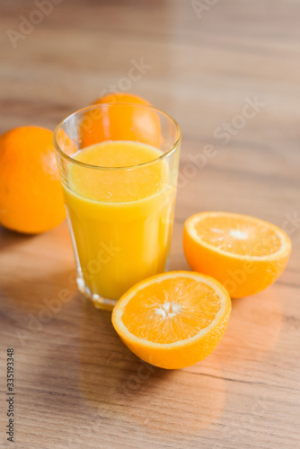 Oranges in peel and cut and juice-fresh on the wooden table of the house. Useful food, vitamins for health.

