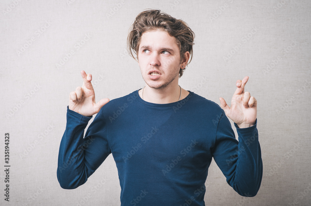 man crossed her fingers for luck. Gray background man crossed her fingers for luck. Gray background