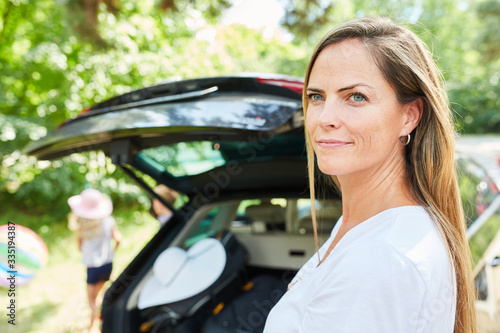 Frau steht vor der Abreise am Auto