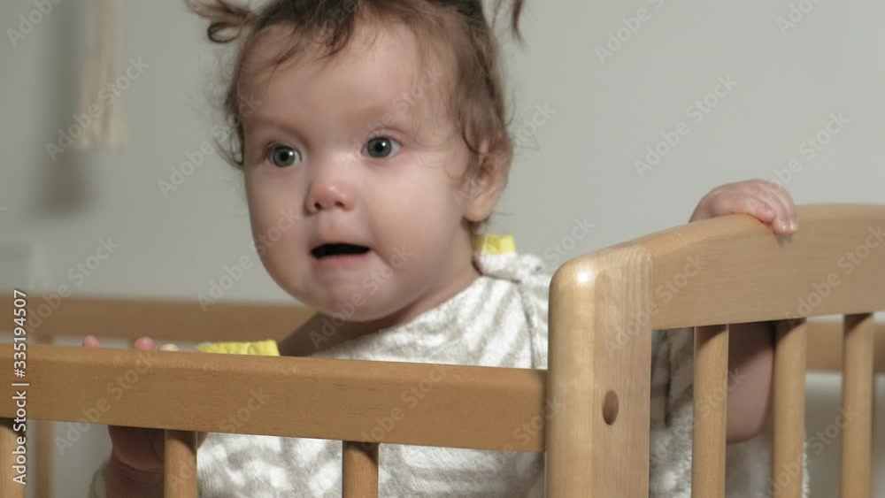 A small child plays in the crib. A small child plays in the crib.