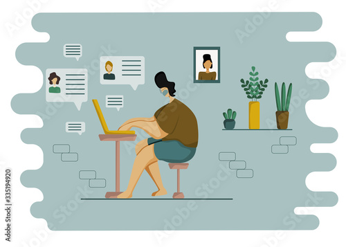 A young man in a protective mask is sitting at home at his laptop, receiving messages from his friends, colleagues or relatives. Concept of online communication, remote work during quarantine