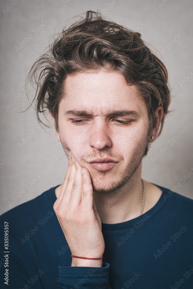 Portrait of young man with toothache