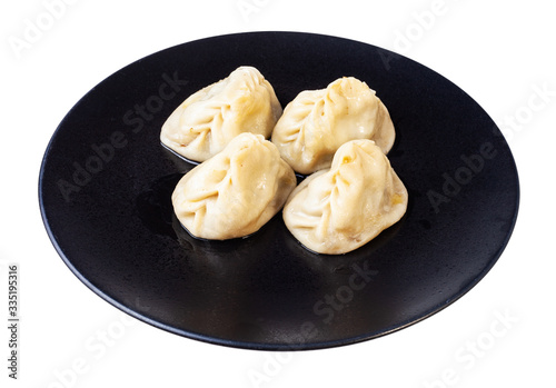 portion of cooked Manti on black plate isolated