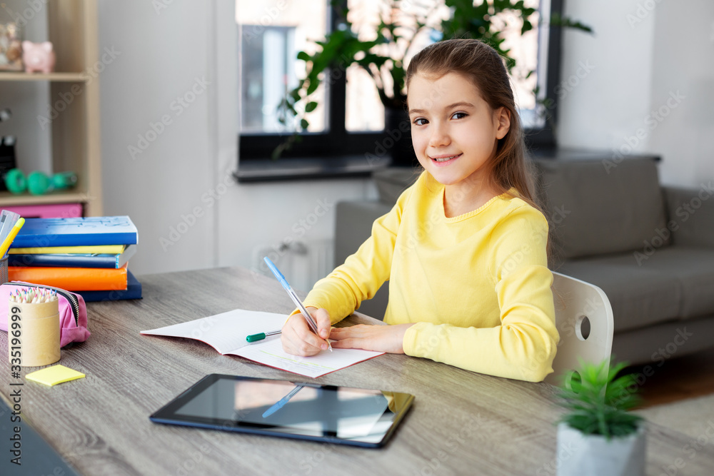 children, education and learning concept - happy student girl with tablet pc computer writing to notebook at home children, education and learning concept - happy student girl with tablet pc computer writing to notebook at home