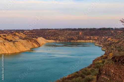 View of a lake with sandy shores in flooded sand quarry
