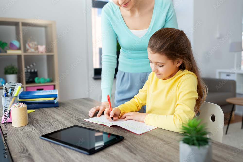 education, family and learning concept - mother and daughter with tablet pc computer and notebook doing homework together at home education, family and learning concept - mother and daughter with tablet pc computer and notebook doing homework together at home