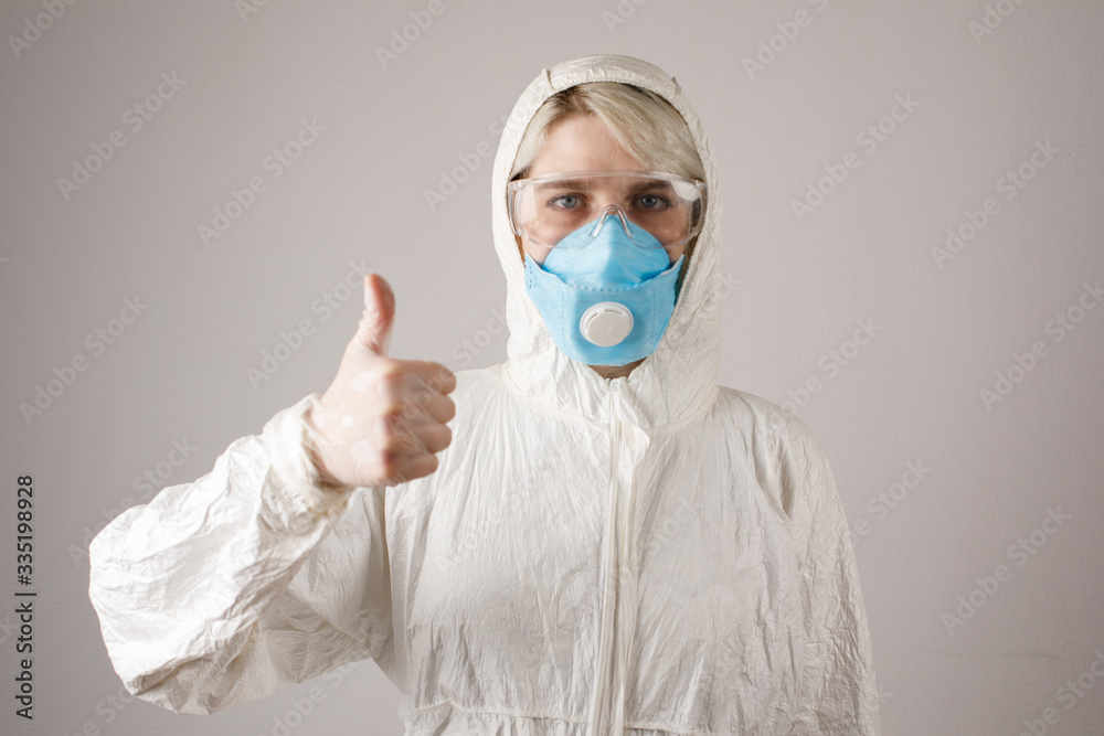 A girl in a protective suit and a respirator to protect health from viral, epidemic and infectious diseases. New Covid-19. Corona virus pandemic concept. Stop the virus. A girl in a protective suit and a respirator to protect health from viral, epidemic and infectious diseases. New Covid-19. Corona virus pandemic concept. Stop the virus.