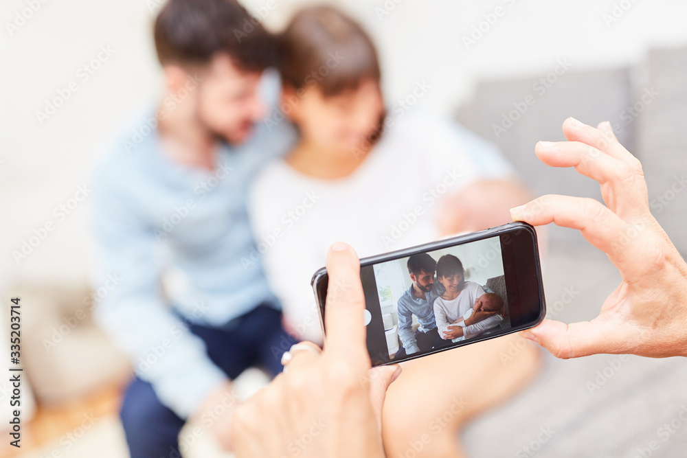Smartphone macht Foto von Eltern mit Baby