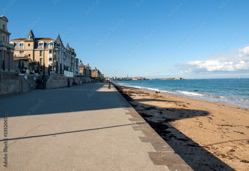 People walking along promenade at seafront in Saint Malo, Brittany, France