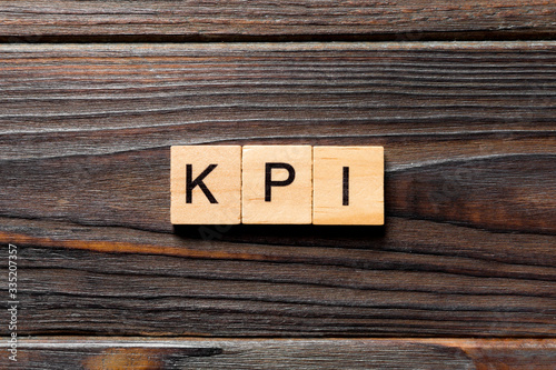 kpi word written on wood block. kpi text on table, concept