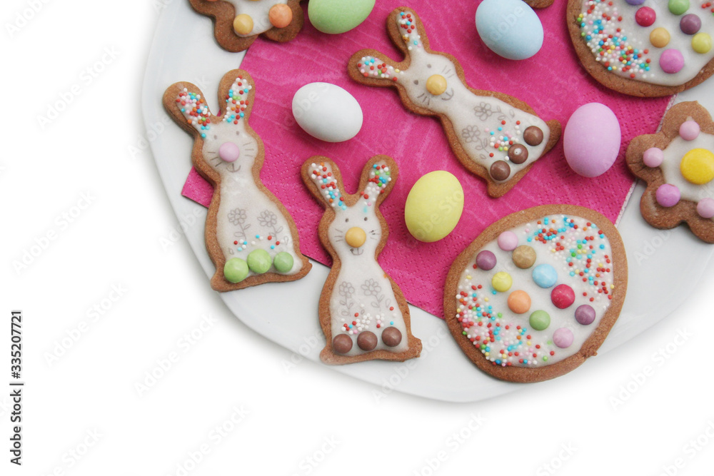 Homemade Easter cookies in shape of bunny and Easter eggs on a plate on white background. Springtime background on selective focus
