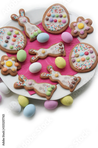 Homemade Easter cookies in shape of bunny and Easter eggs on a plate on white background. Springtime background on selective focus 