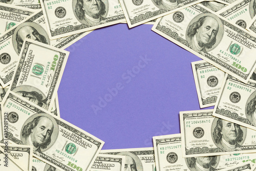 Frame made of dollars with copy space in the middle. Top view of business concept on purple background with copy space