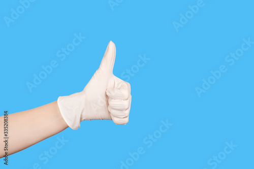 Hand in a white latex glove showing thumbs up sign isolated on white background.