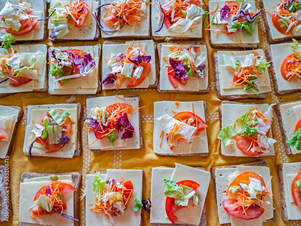 Close up overhead shot of cheese salad sandwiches being made ready for delivery to a food charity service run in Geneva, Switzerland.