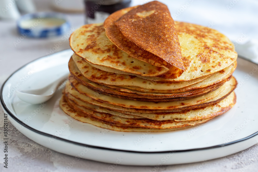 Fresh baked french crepes or Russians blinis on beautiful plate.