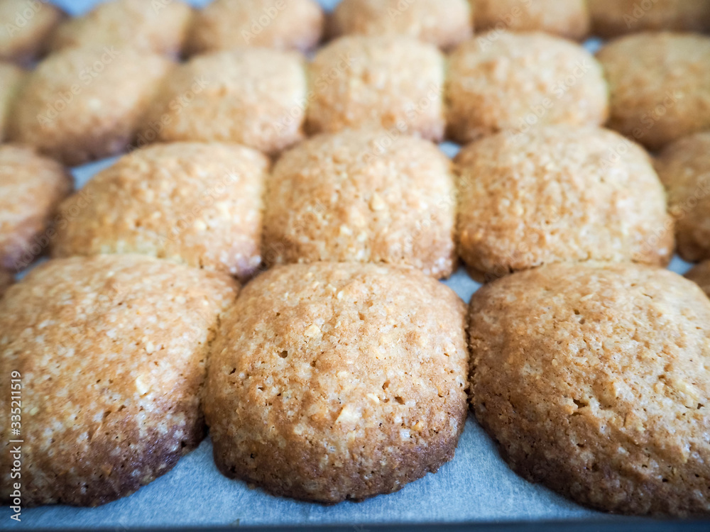 Gluten-free round cookies of light brown color from buckwheat and corn flour with cashew nuts on a baking sheet Gluten-free round cookies of light brown color from buckwheat and corn flour with cashew nuts on a baking sheet