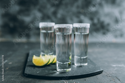 Tequila shots on the dark rustic background. Selective focus. Shallow depth of field.