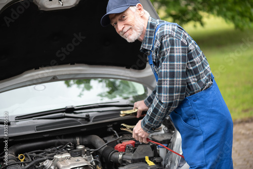 Car mechanic using car battery jumper cable