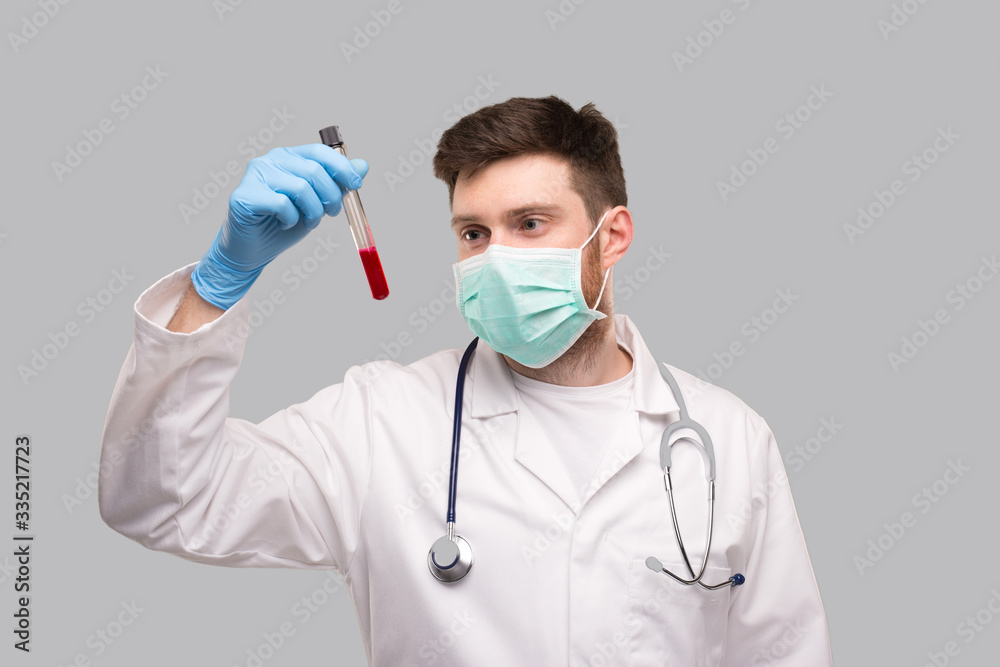 Male Doctor Checking Intently Blood Analysis Wearing Medical Mask and Gloves. Portrait. Virus Analysis Concept Male Doctor Checking Intently Blood Analysis Wearing Medical Mask and Gloves. Portrait. Virus Analysis Concept