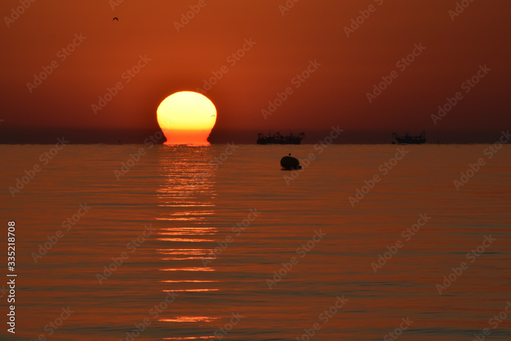 Alba a Riccione con pescherecci al lavoro