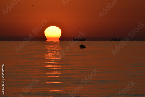 Alba a Riccione con pescherecci al lavoro