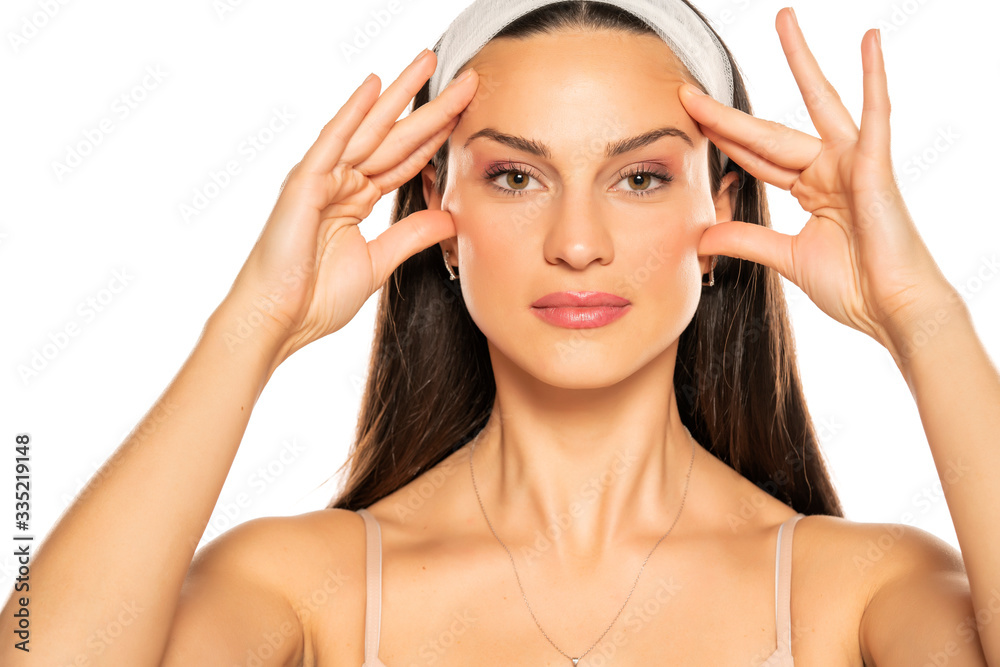 young woman tightening her face with her fingers young woman tightening her face with her fingers