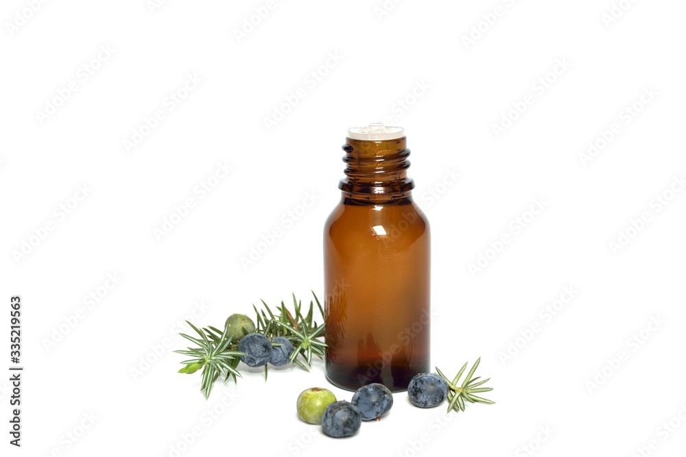 Fototapeta premium Olejek eteryczny i gałązka jałowca z fioletowymi owocami na białym tle