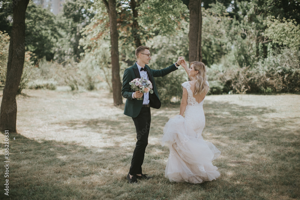Portrait of a lovely bride and groom embrace, kiss and hug each other. Couple in love in the bosom of nature . Handsome groom and beautiful blonde bride posing in the forest. Modern dress and suit Portrait of a lovely bride and groom embrace, kiss and hug each other. Couple in love in the bosom of nature . Handsome groom and beautiful blonde bride posing in the forest. Modern dress and suit