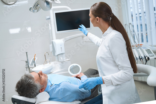 Female dentist consulting male in office stock photo