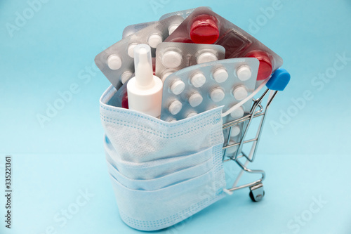 Medical mask on the colorful assorted pills patternof medicine pills colorful medicine on blue background. Health care concept photo