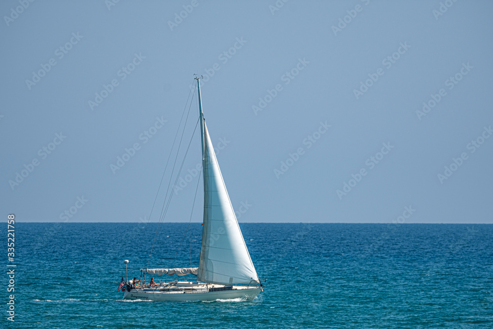sailing boat sailing by the sea near the beach