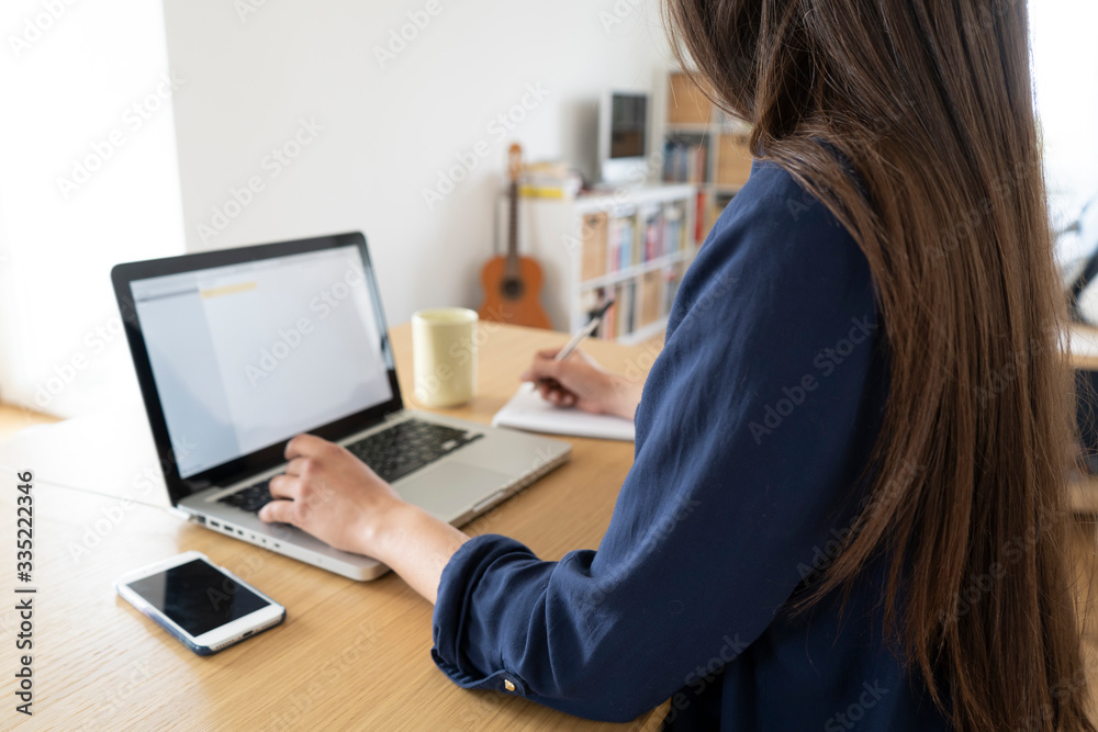 Smart working, young woman working from home on her laptop computer Smart working, young woman working from home on her laptop computer