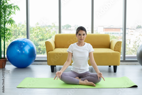 Asian woman yoga exercising at home